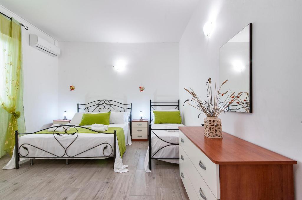 um quarto com 2 camas, uma cómoda e um espelho em ASZ APARTMENTS em Torre Lapillo