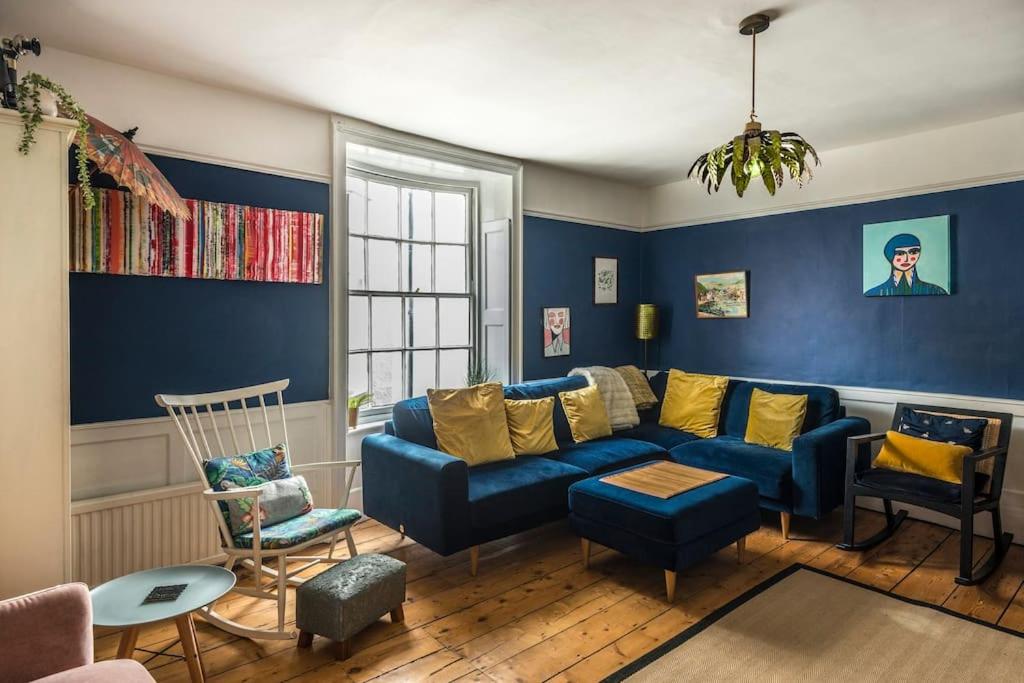 a living room with a blue couch and chairs at The Old Post Office - Truly unique, quirky house in Kent