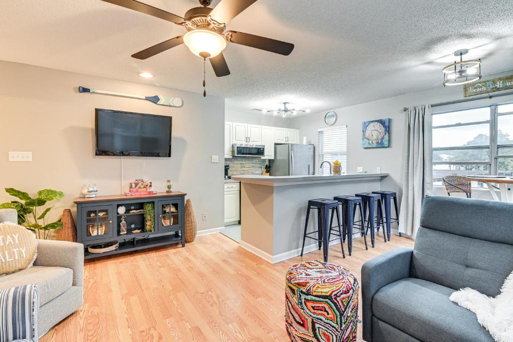 a living room with a couch and a bar with stools at Myrtle Beach Retreat with Balcony Near Boardwalk! in Myrtle Beach