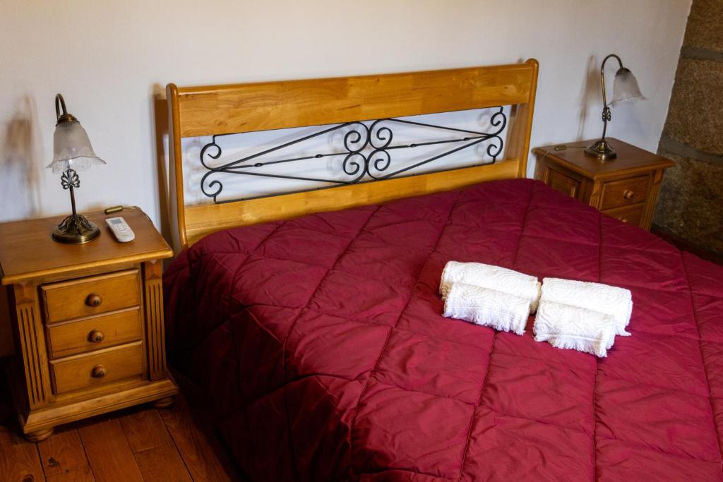 - une chambre avec un lit rouge et deux oreillers blancs dans l'établissement Quinta das Amendoeiras, à Mêda