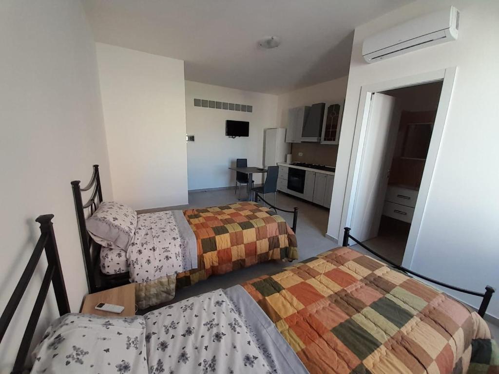 1 dormitorio con 2 camas y cocina en Irpinia Verde, en Mirabella Eclano