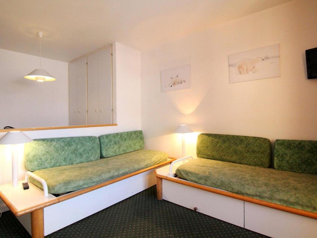 een kamer met twee groene stoelen en een tafel bij Appartement cosy 4 pers, navette proche, balcon - Alpe d'Huez - FR-1-405-166 in Huez