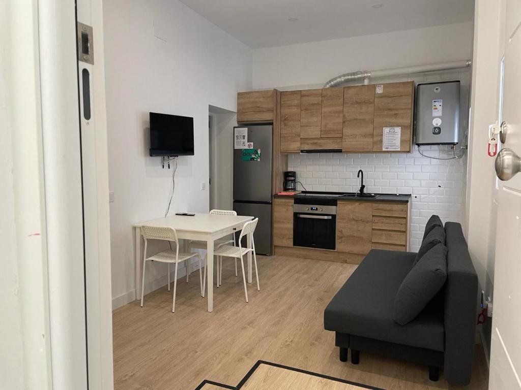 a living room with a table and a kitchen at U1 Ap Nuevo, bien comunicado Madrid centro in Madrid