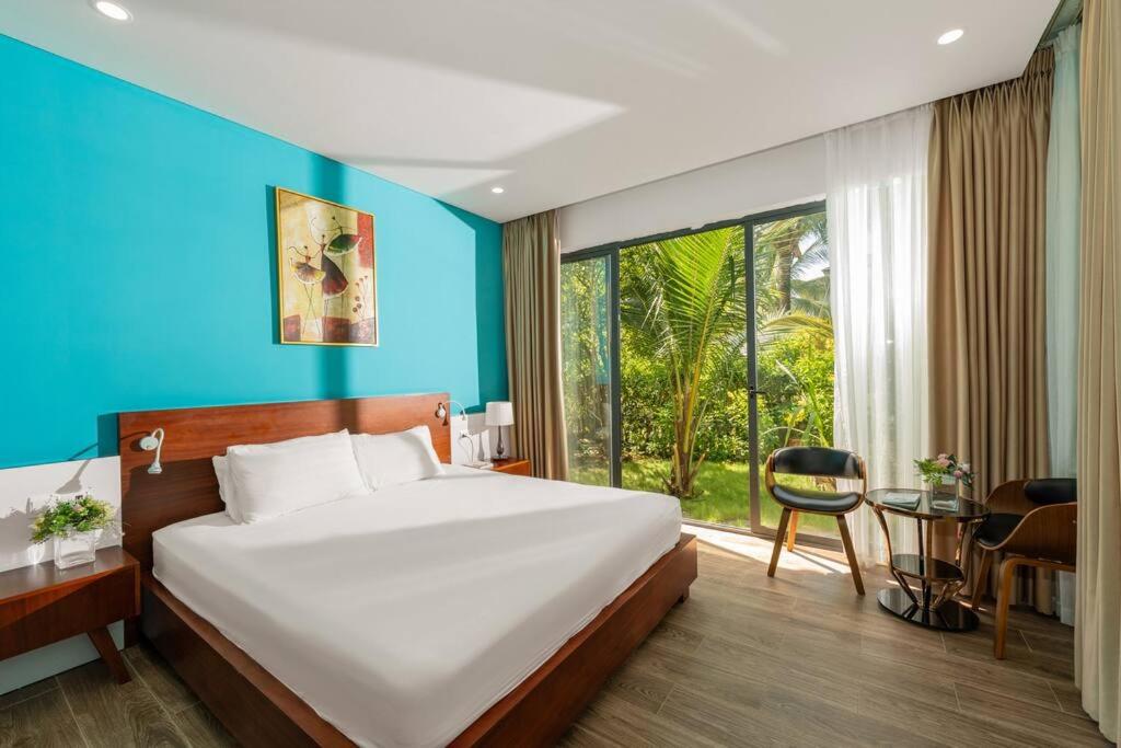 een slaapkamer met een groot bed en een groot raam bij 4BR Villa Near The Beach & Shared Pool in Phu Quoc