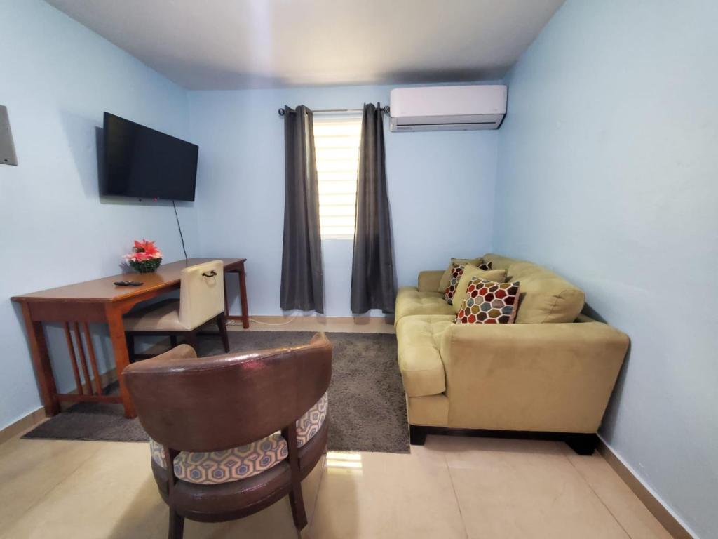 a living room with a couch and a desk and a television at Spacious 2 BR, fully equipped kitchen close to Ferry, Unit 5 in Catano