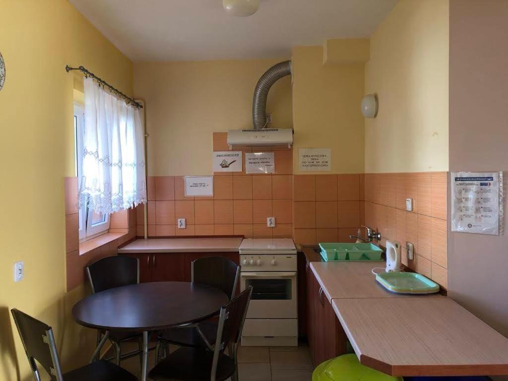 a small kitchen with a table and a table and a table and chairs at Pokoje Bałtycka 4 in Mrzeżyno