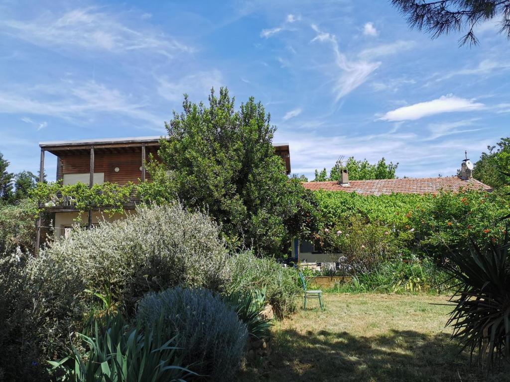 a house in a garden with trees and bushes at La verdine in Arles