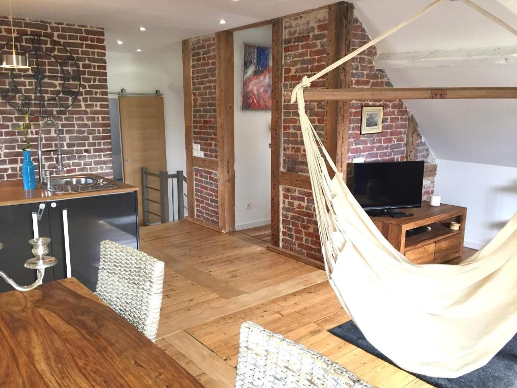 a hammock in a living room with a table and chairs at Le Loft du Clocheton in Étretat