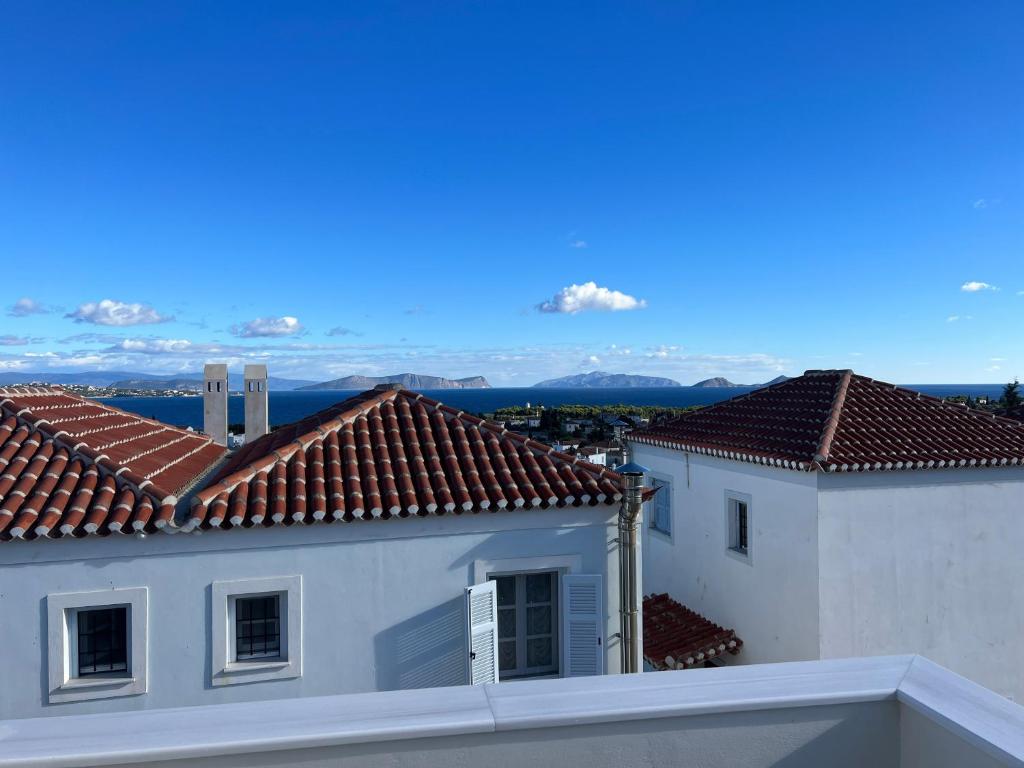 斯佩察島的住宿－Spetses maisonette 2 bedrooms for 6 persons.，享有两座白色建筑和红色屋顶的景色