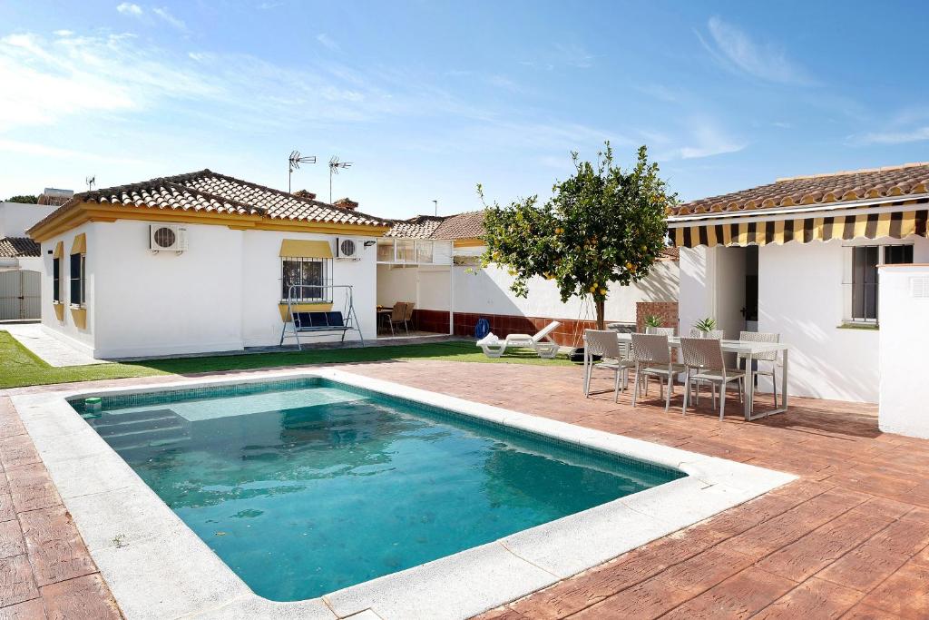 a swimming pool in the backyard of a house at Chalet Mesana in Chiclana de la Frontera