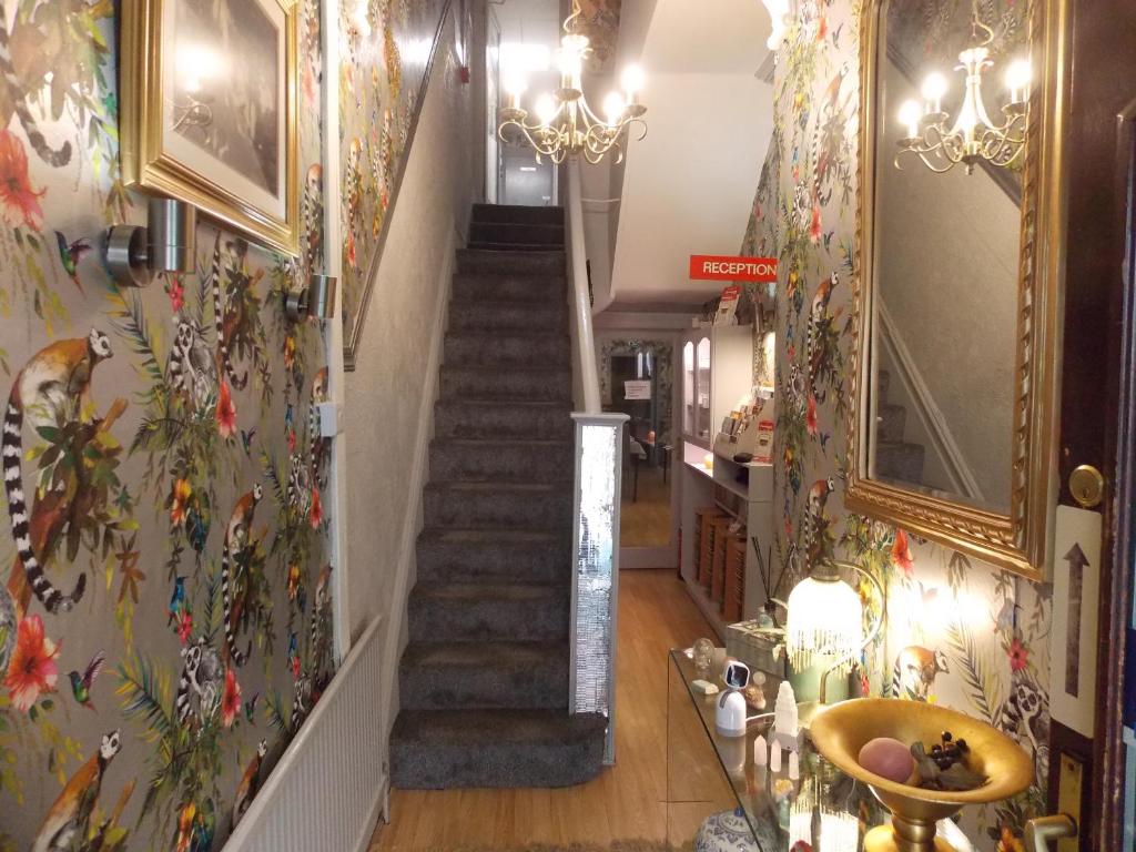 a hallway with a staircase with flowers on the wall at The Rockley Hotel in Blackpool