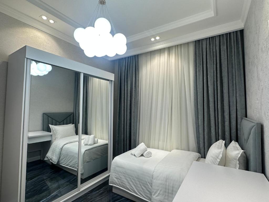 - une chambre avec 2 lits et un miroir dans l'établissement YakkaSaray Premium Apartment, à Tachkent
