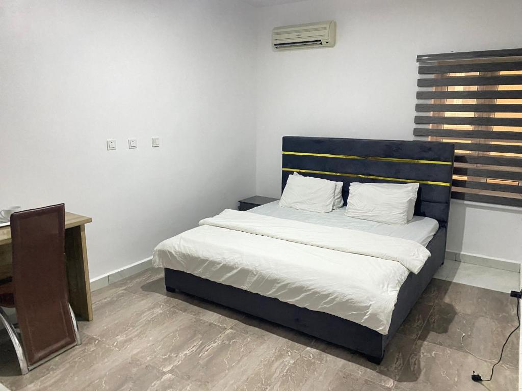 een bed met een blauw hoofdeinde in een kamer bij CHRIS SPORSHE in Abuja