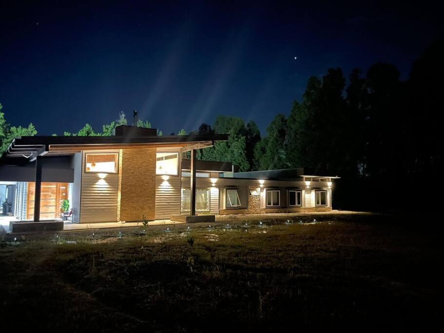 une maison éclairée la nuit avec des lumières dans l'établissement Casa familiar en el campo, 