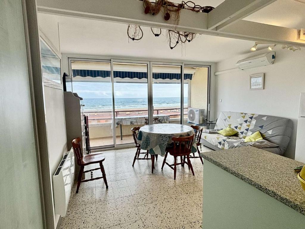 une cuisine et un salon avec une table et des chaises dans l'établissement Appt 2 pièces 4 pers climatisé avec balcon, parking et animaux admis à 150m de la plage - FR-1-229C-46, à Port-la-Nouvelle