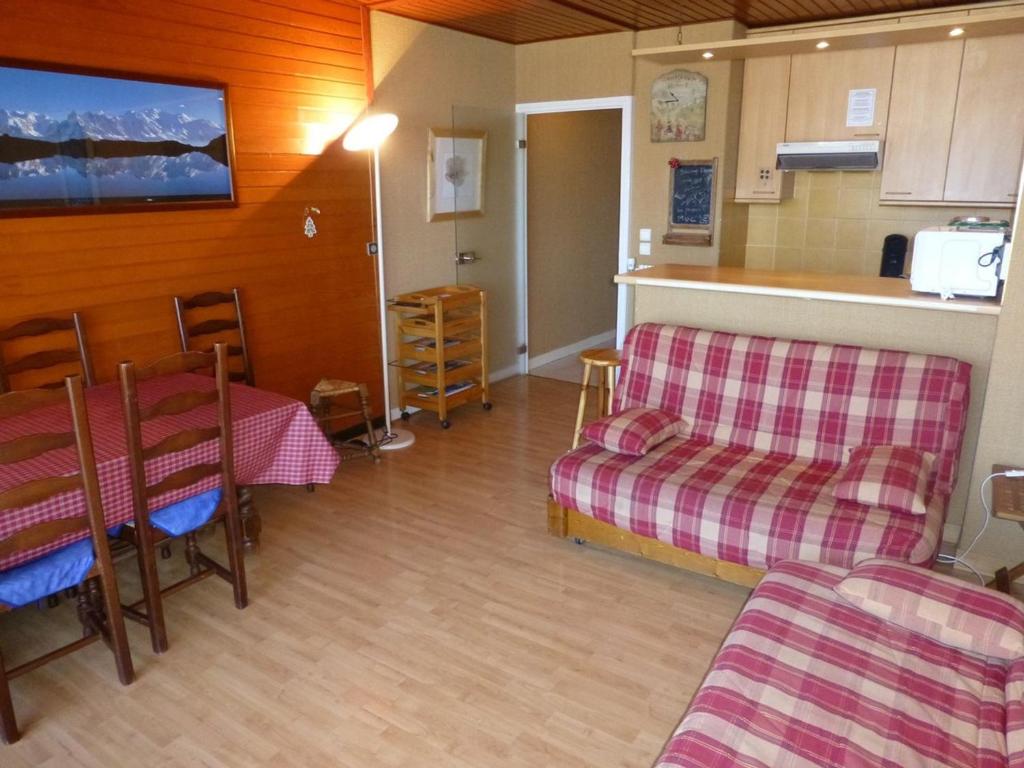 a living room with a table and chairs and a kitchen at Appartement Huez, 2 pièces, 6 personnes - FR-1-405-194 in LʼHuez