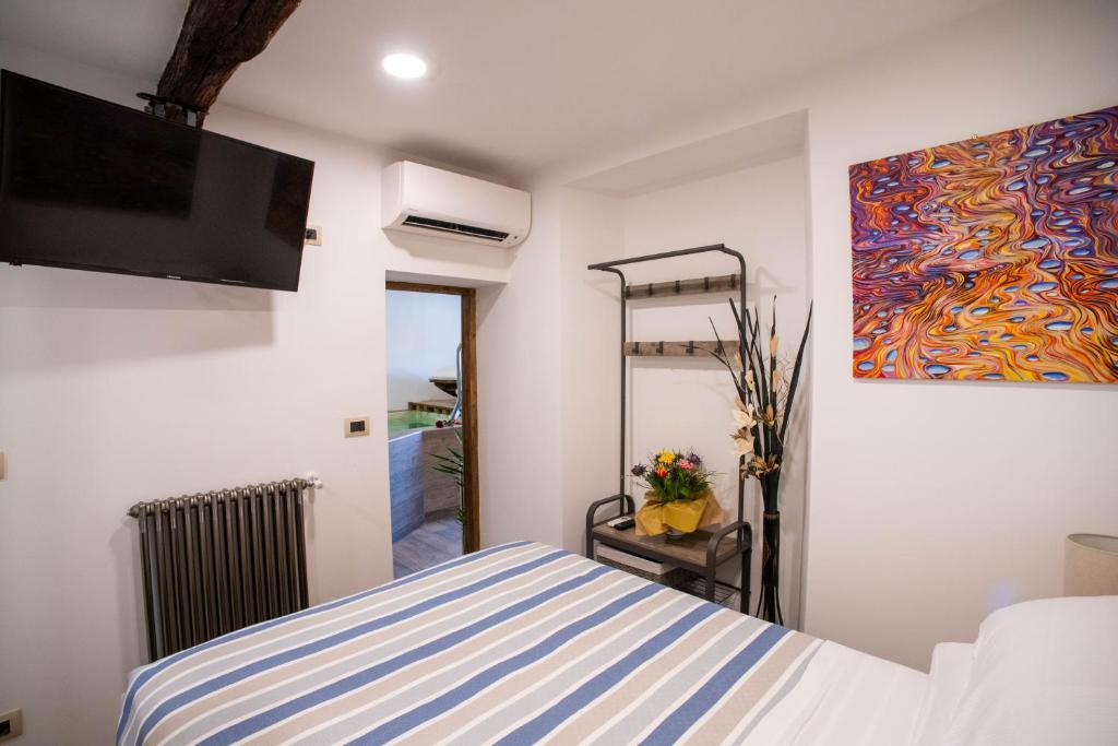 a bedroom with a bed and a painting on the wall at Podere Maletto - Appartamento con PISCINA INTERNA riscaldata Savona in Savona