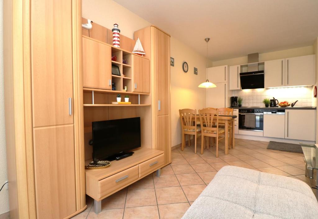 a living room with a television and a kitchen at Altes Wasserwerk App 09 in Wustrow