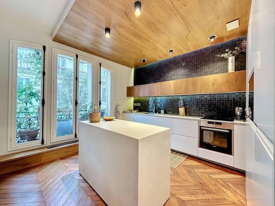 une cuisine avec un comptoir blanc et quelques fenêtres dans l'établissement Anvers, à Paris