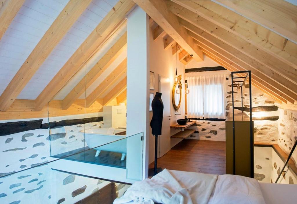 Verzasca Lodge Ofelia في Sonogno: غرفة نوم علوية بحائط زجاجي