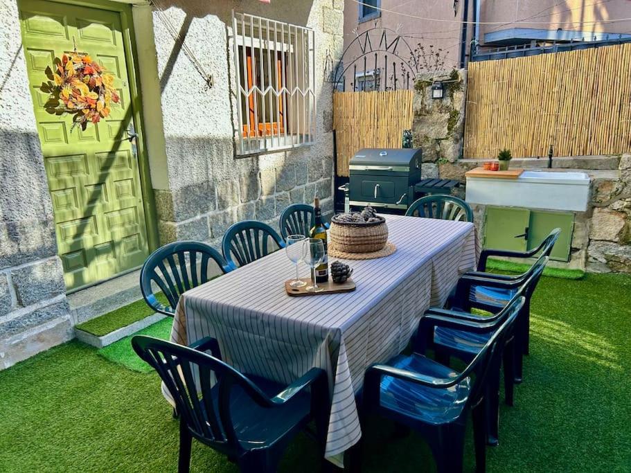 een tafel en stoelen met een tafel en een grill bij Casa Rural, “El Andador” in Hoyo de Pinares