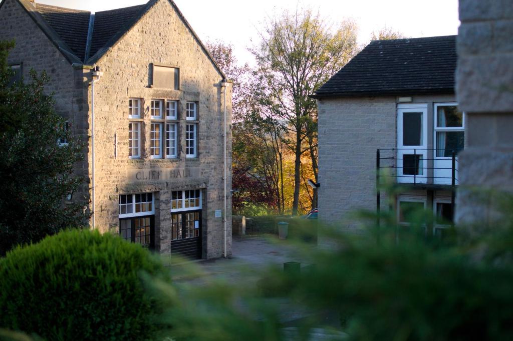 a large brick building with a gate in front of it at Cliff College in Curbar