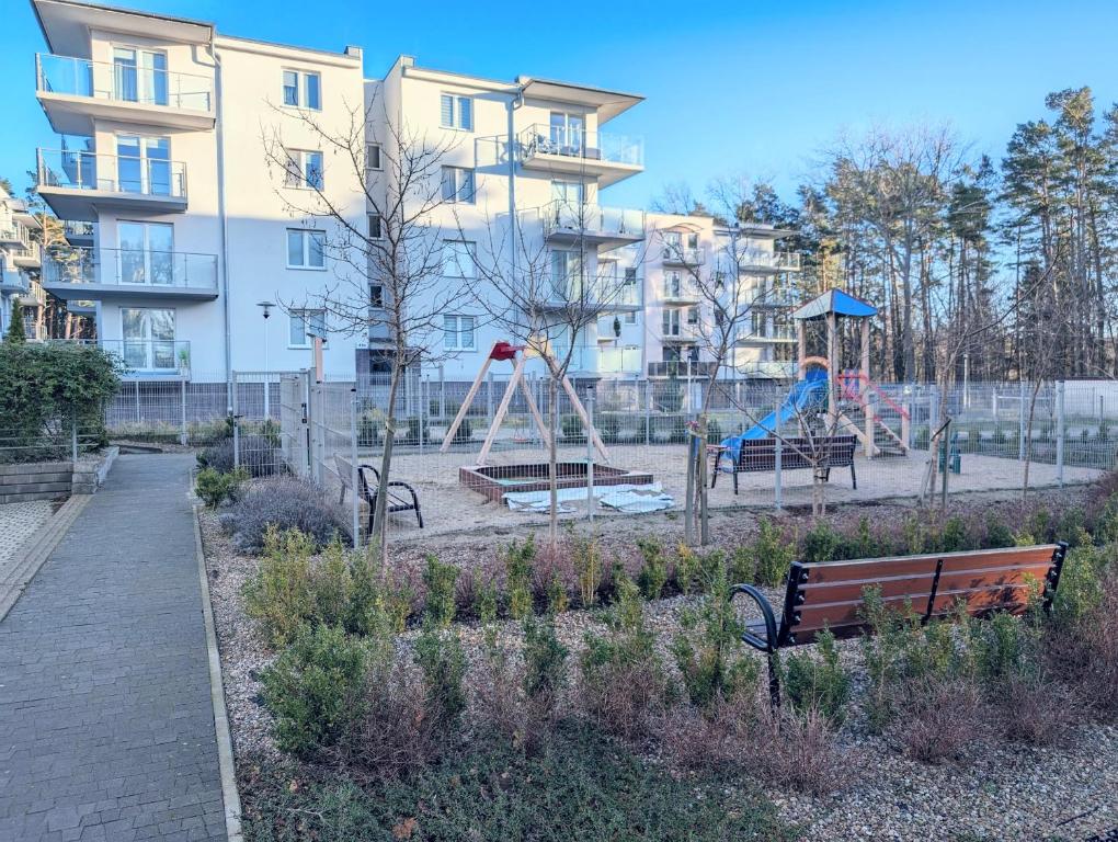 a park with benches and a playground in front of a building at Sea Suite, 150 meters to beach, Baltic Best in Dziwnówek