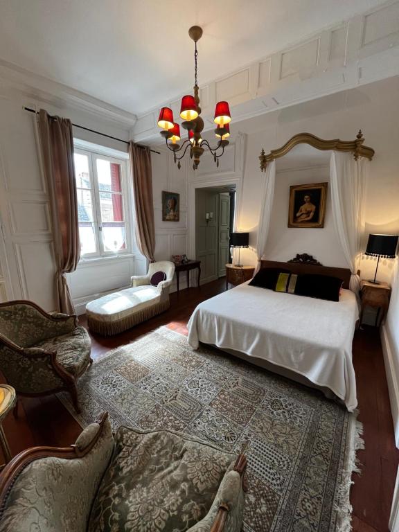 a bedroom with a bed and a couch and a chair at Le Logis de Saint Cyr in Issoudun