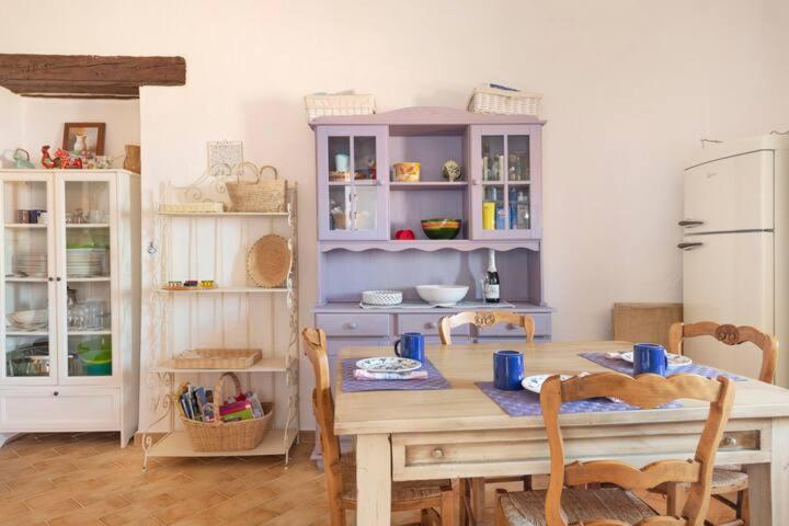 a kitchen with a table with chairs and a dining room at Vicolo della Luna in Castelsardo