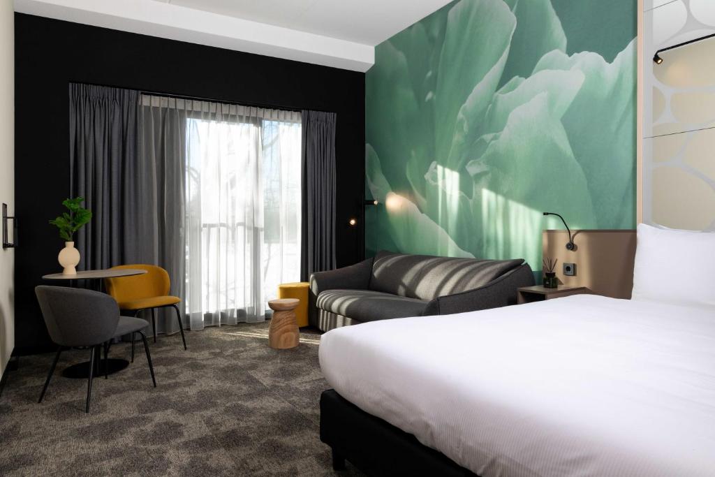 Habitación de hotel con cama y sofá en Otium Hotel Roosendaal en Roosendaal