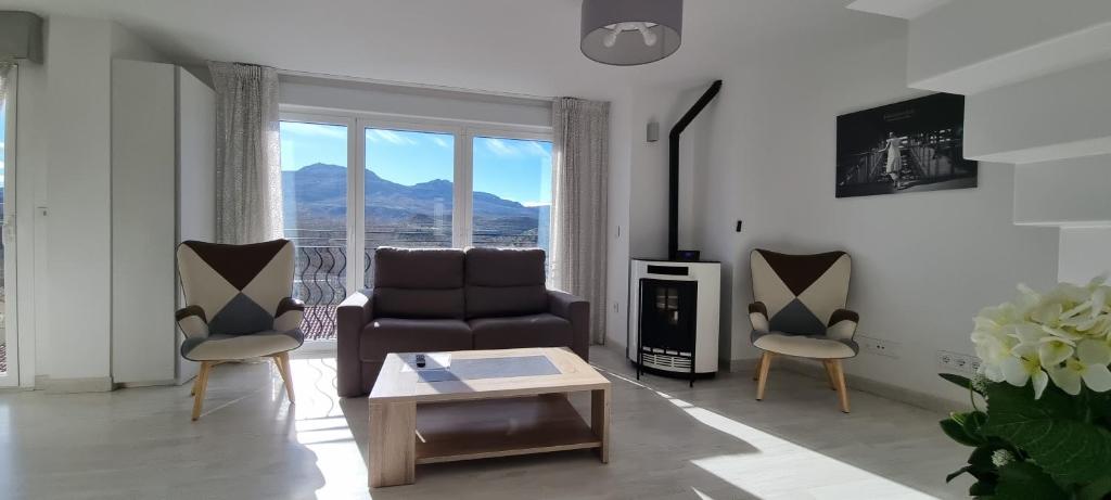 a living room with a couch and two chairs at Apartamentos Miradores del Isasa in Herce