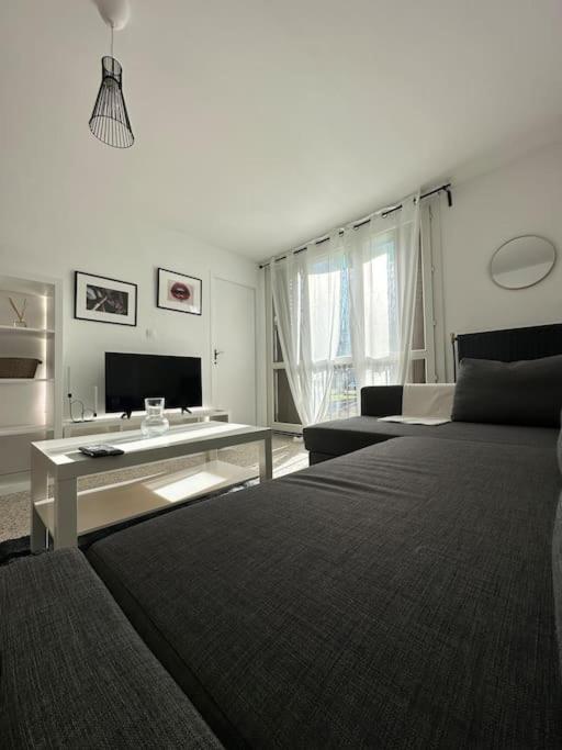 a white living room with a bed and a table at Le Phoenix, proche stations ski et Campus Univers. in Gières
