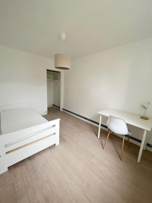 a white room with a bed and a table and a chair at Le Phoenix, proche stations ski et Campus Univers. in Gières