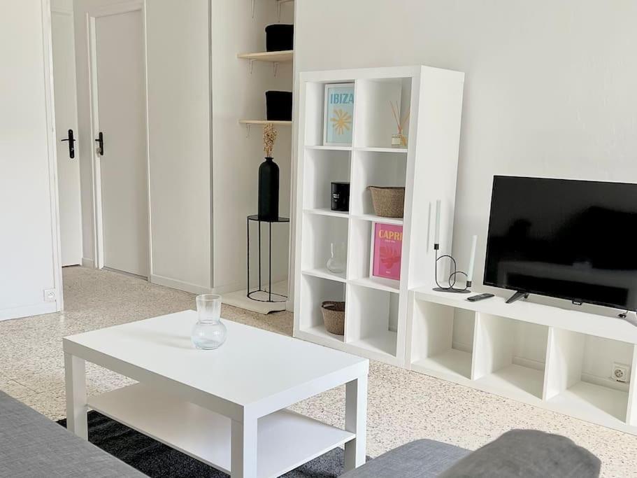 a white living room with a tv and a white table at Le Phoenix, proche stations ski et Campus Univers. in Gières