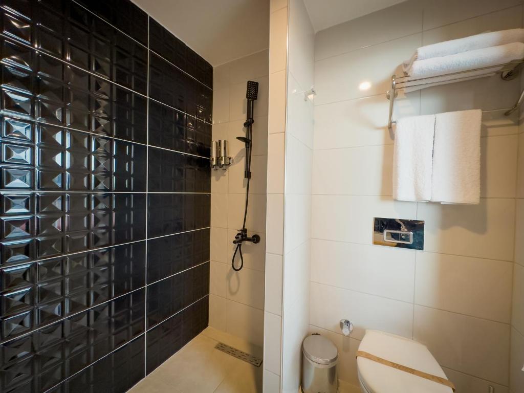 a bathroom with a toilet and a shower at Mihman Hotel in Tuzla