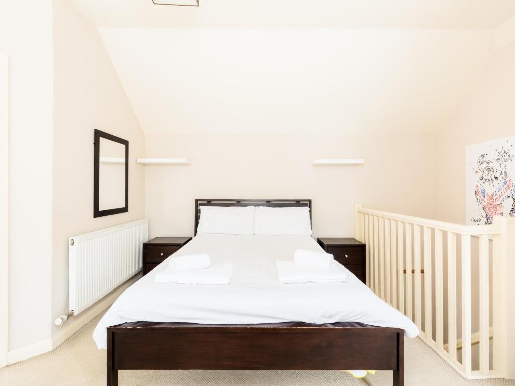um quarto com uma cama grande e lençóis brancos em Pass the Keys Self Contained 1 Bed Coach House em Leamington Spa