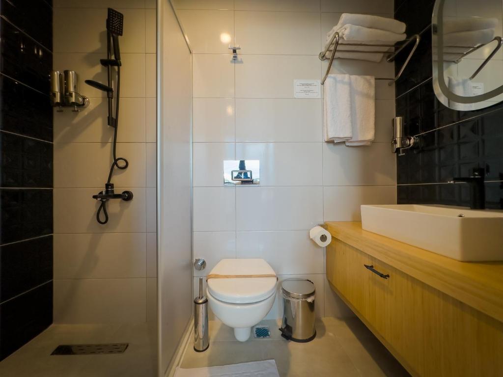 a bathroom with a toilet and a sink at Mihman Hotel in Tuzla