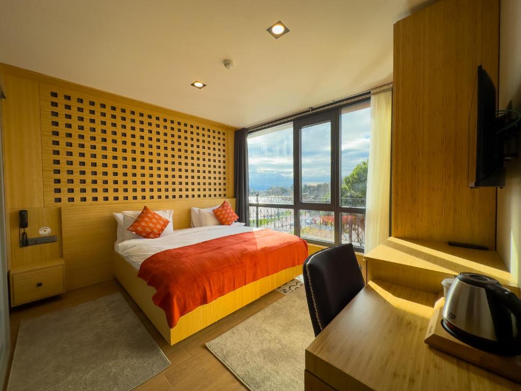 a bedroom with a bed and a large window at Mihman Hotel in Tuzla