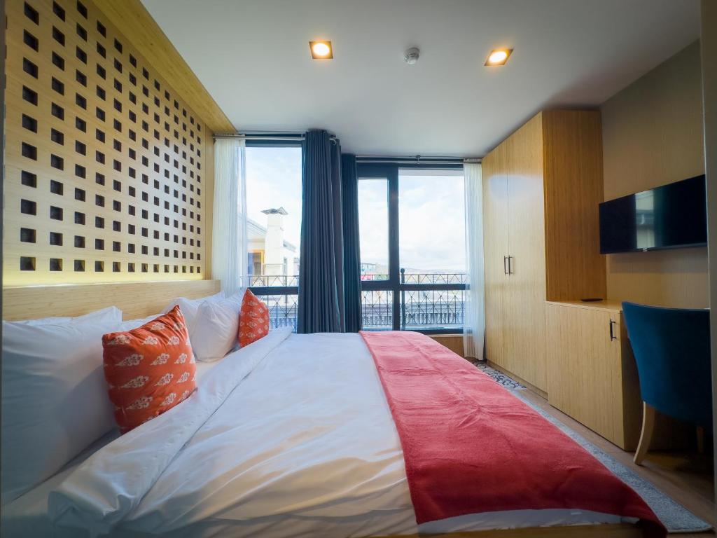 a bedroom with a large bed with a large window at Mihman Hotel in Tuzla