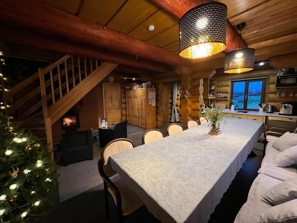 a dining room with a table and a christmas tree at Kundziņu salas in Vidriži
