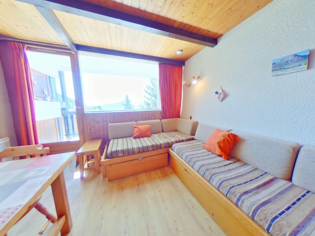 un salon avec un canapé et une grande fenêtre dans l'établissement Studio Alcôve Central Les Saisies, 4 Pers, Balcon, 1er Étage, Proche Commerces et Navettes - FR-1-594-201, à Hauteluce