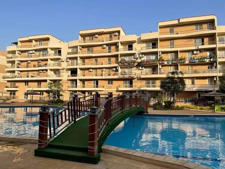 a large apartment building with a bridge over a pool at Pyramids and Museum Resort /villa in Giza