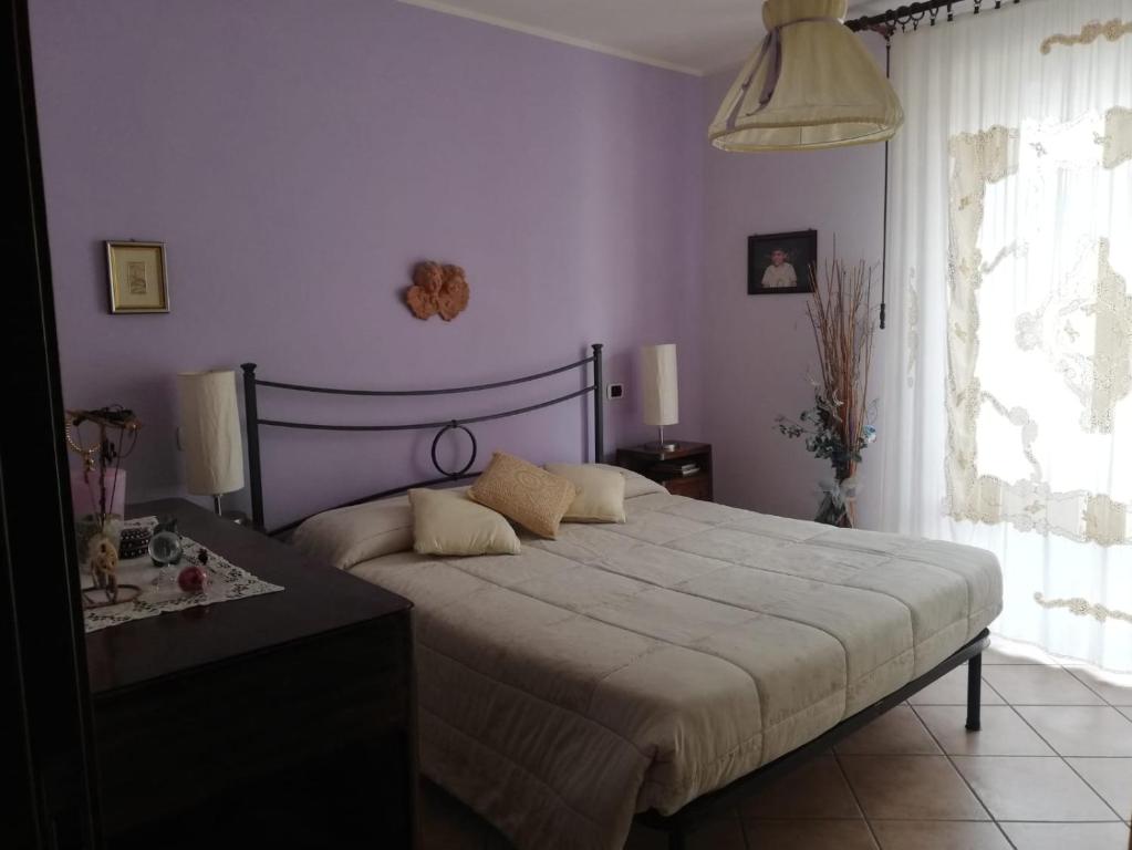 sypialnia z dużym łóżkiem i fioletowymi ścianami w obiekcie Locazione turistica vicino Orvieto w mieście Orvieto Scalo
