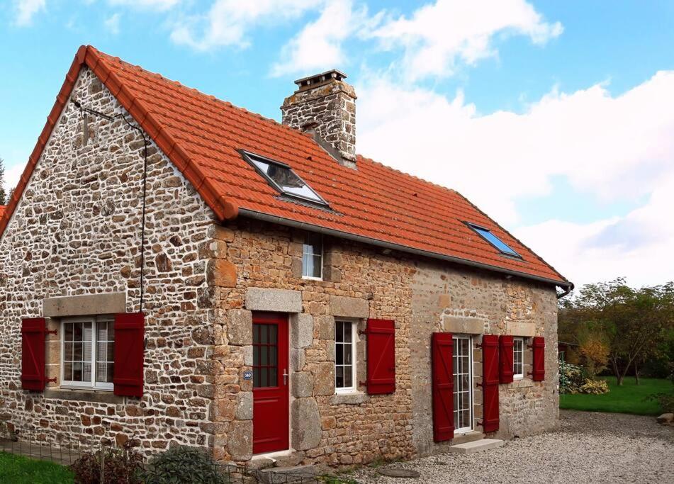 een bakstenen gebouw met rode ramen en een rood dak bij La petite corbière - Chez Hélène - Gîtes en baie in Jullouville-les-Pins