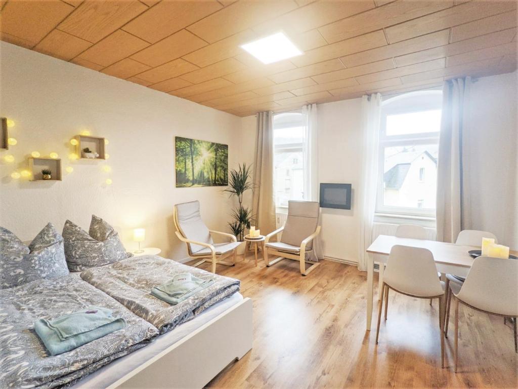 a bedroom with a bed and a table and chairs at Urlaubsmagie - Helle Wohnung mit Garten & Pool - R3 in Rathmannsdorf