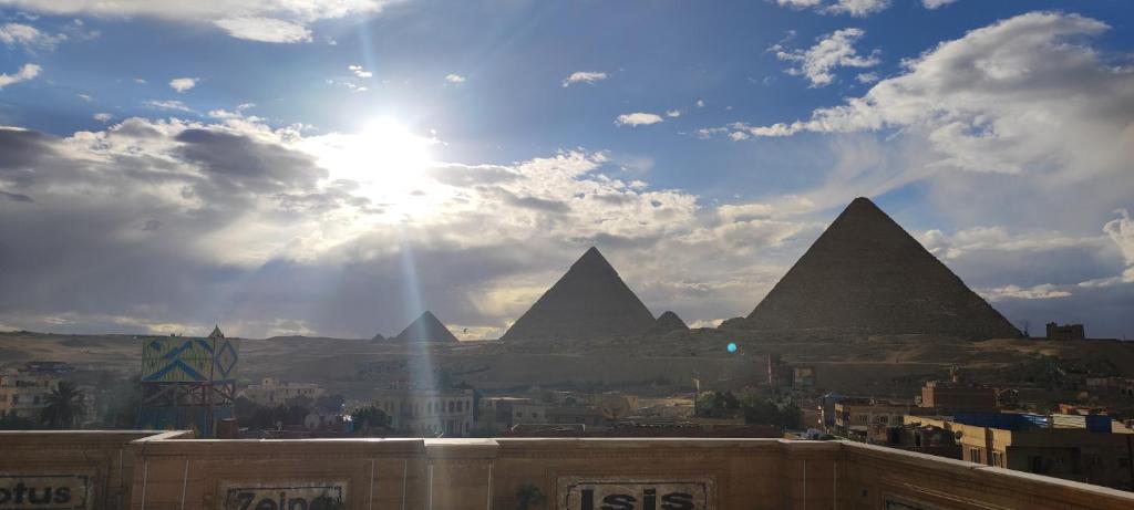 einen Blick auf die Pyramiden von Giza unter einem wolkigen Himmel in der Unterkunft Pyramids Kingdom in Kairo