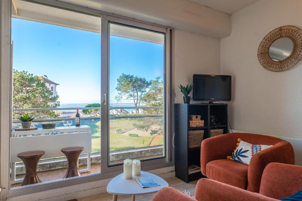 un salon avec une grande fenêtre avec vue sur l'océan dans l'établissement La Jetée du Moulleau - Appt 4 personnes vue Bassin, à Arcachon