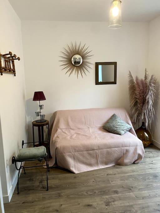 1 dormitorio con cama, silla y espejo en Appartement COSY en Sartilly