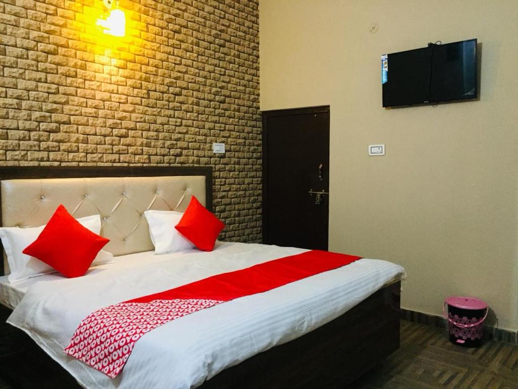 a bedroom with a large bed with red pillows at Divine sparrow family homestay in Agra