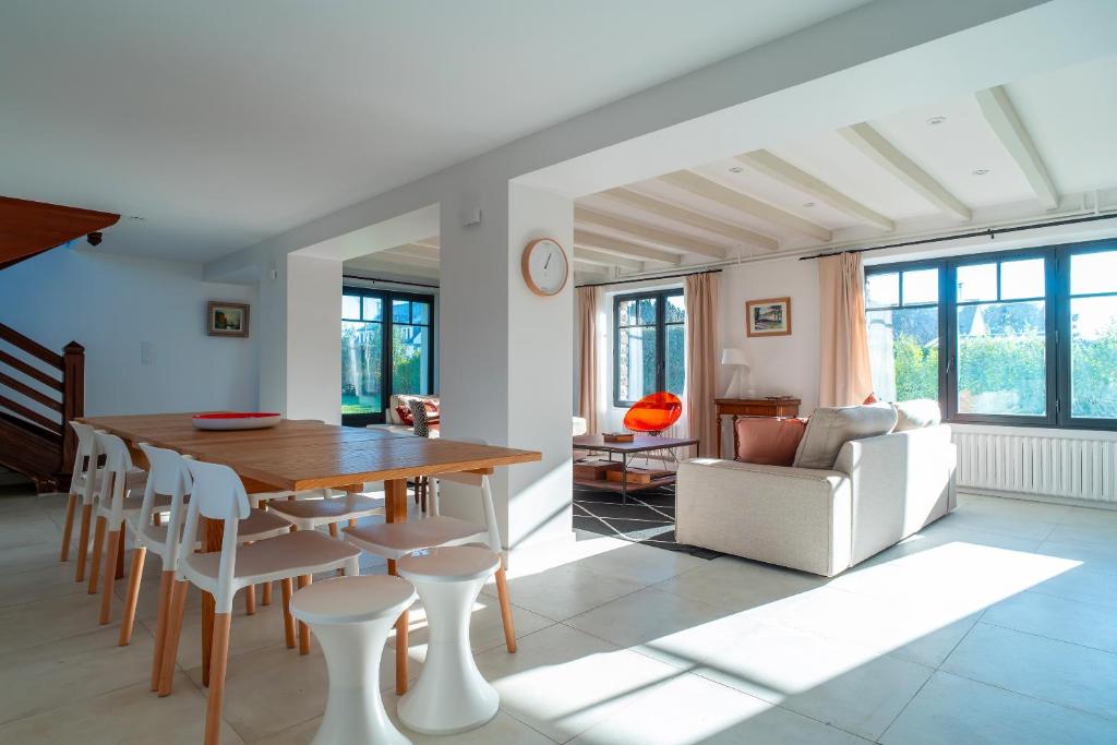 un salon avec une table et des chaises de salle à manger dans l'établissement Portamaneg - Grande maison familiale Port-Manech, à Névez